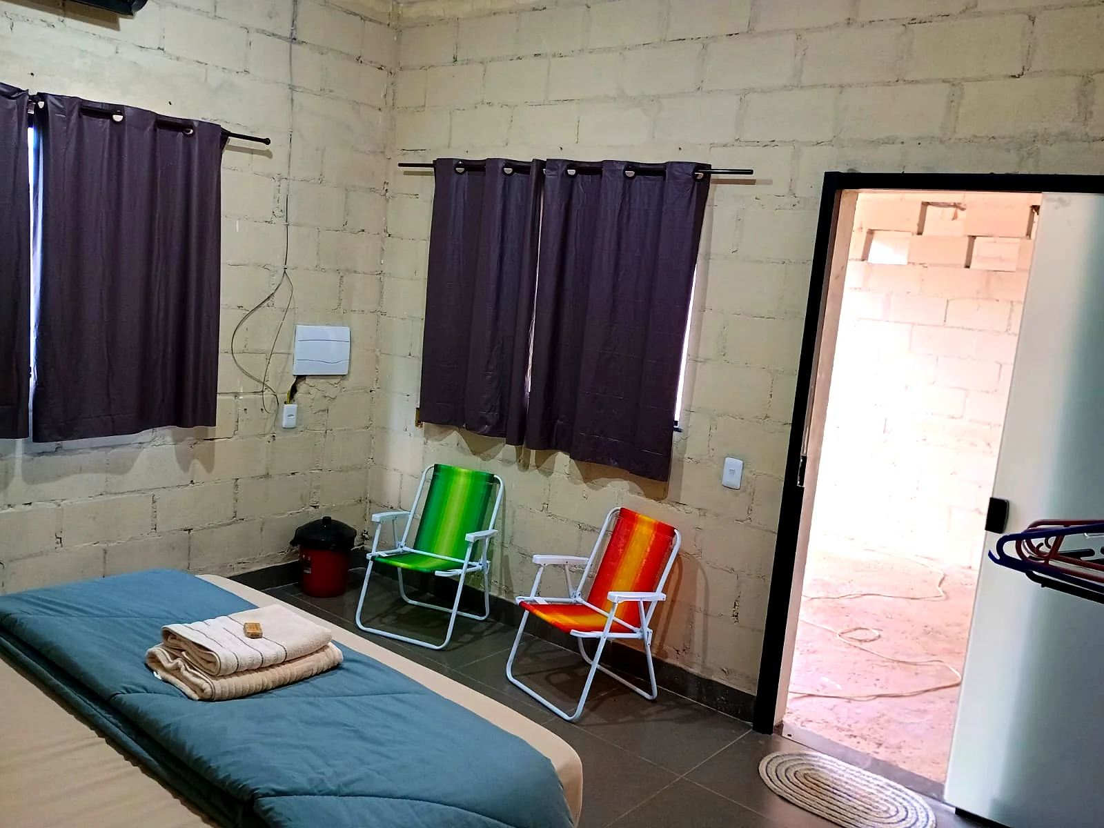 Quarto espaçoso com cadeiras e varanda — Pousada Vale do Jamacá