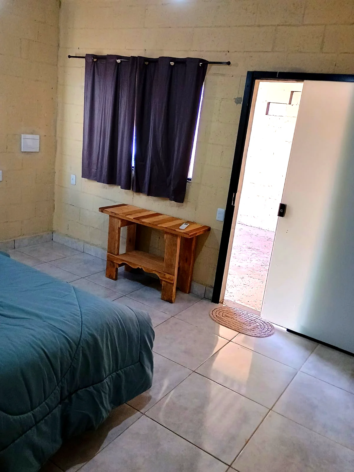 Interior do quarto com banco em madeira maciça — Pousada Vale do Jamacá