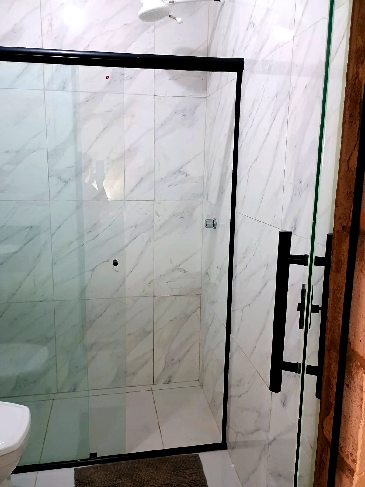 Box de vidro e porcelanato branco — banheiro privativo da Pousada Vale do Jamacá